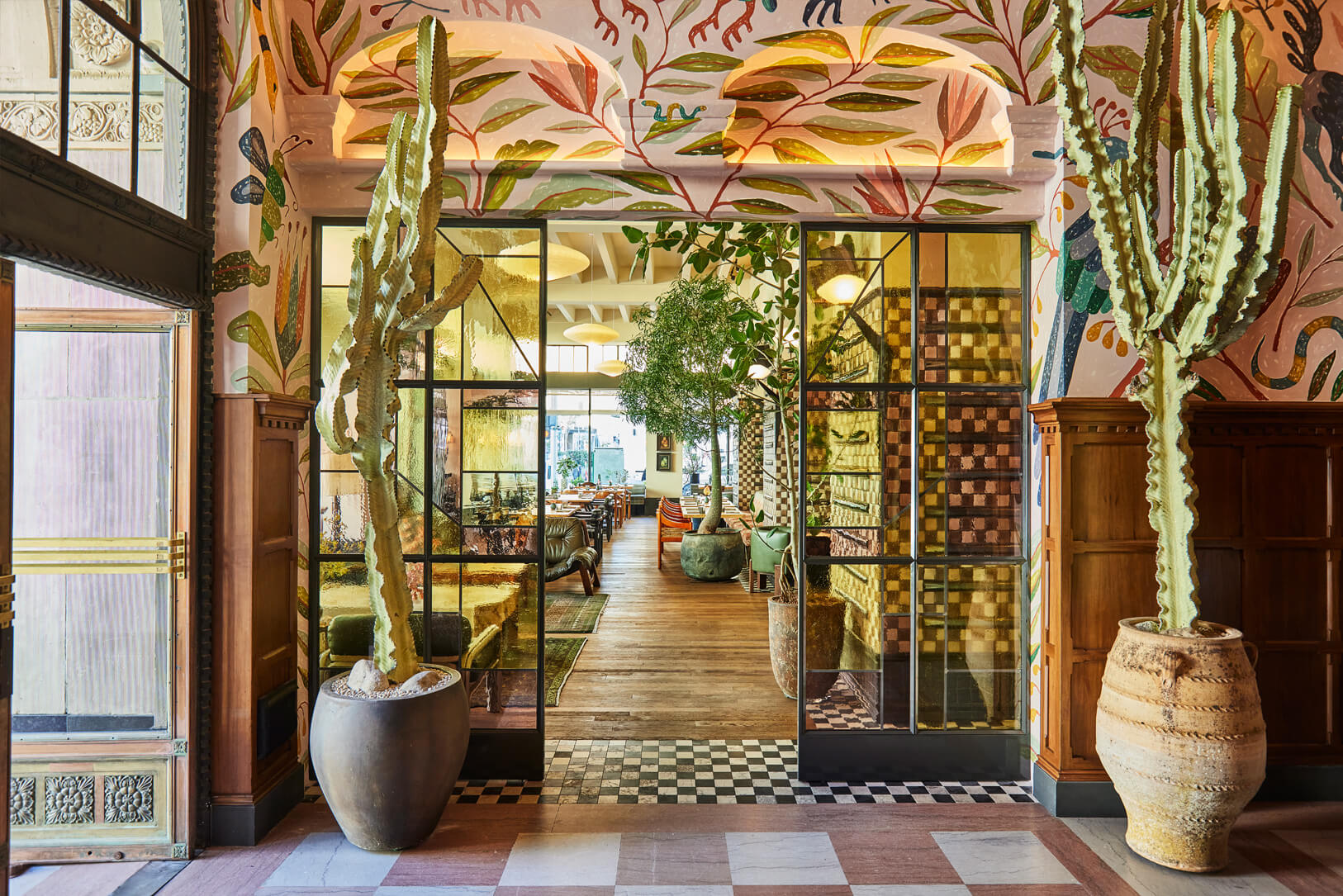 Vibrant lobby entrance with hand painted murals and dramatic cactus lined interiors