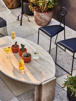 Rooftop lounge seating with handcrafted cocktails, marble table, and desert inspired decor