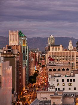 Panoramic Downtown Los Angeles skyline view with city lights and mountain backdrop at dusk