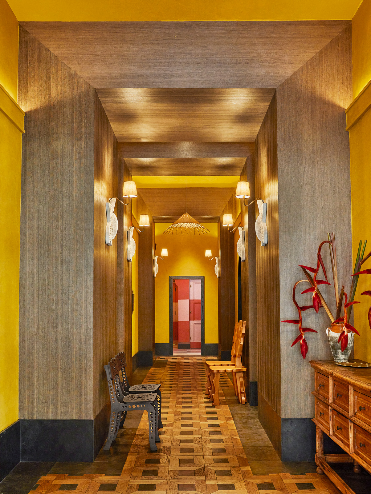Warm-toned hallway with wood paneling, patterned floor, and decorative lighting