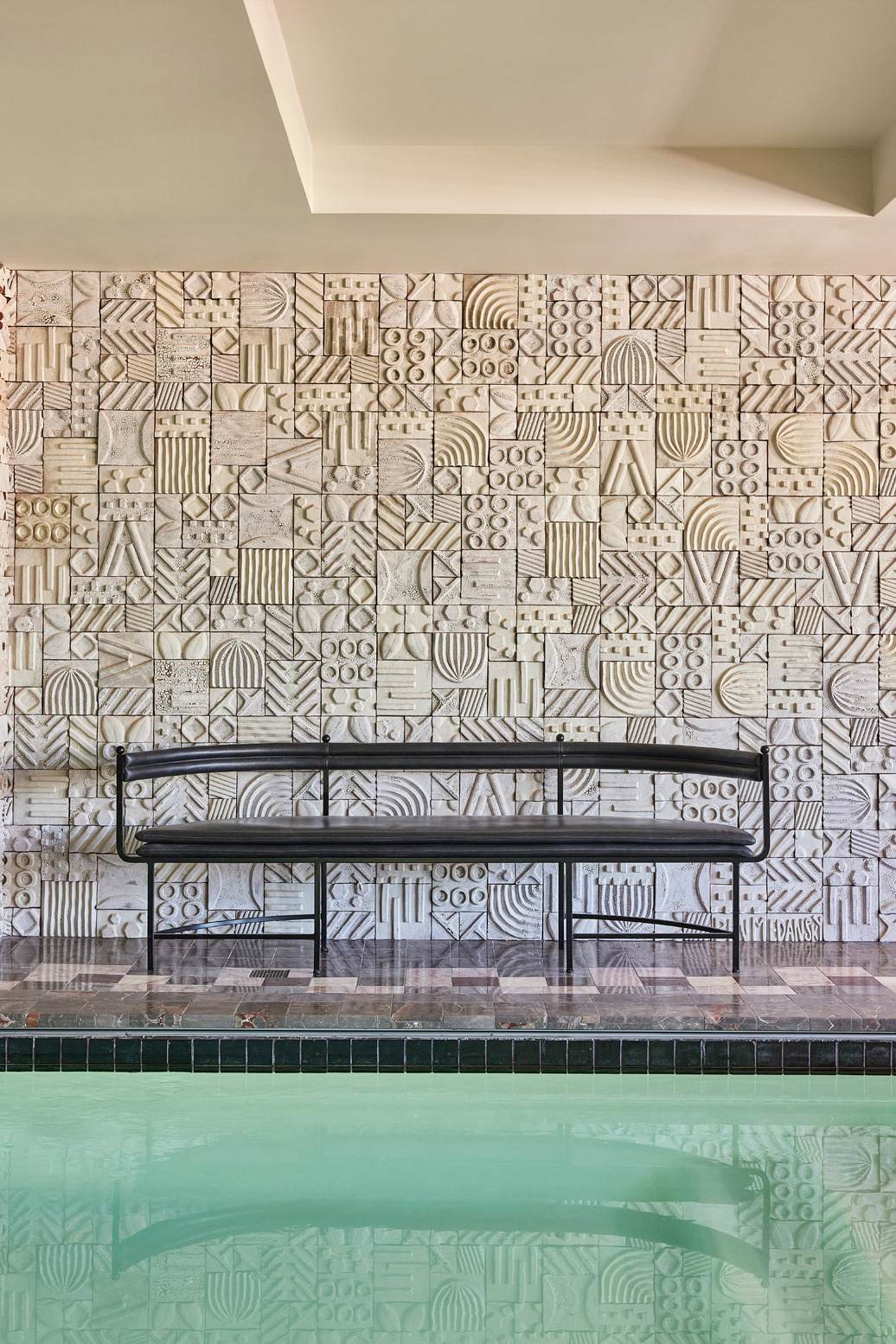 Indoor swimming pool with seating area inside pool suite