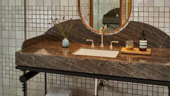 Elegant marble bathroom vanity with brass fixtures, tiled walls, and modern styling