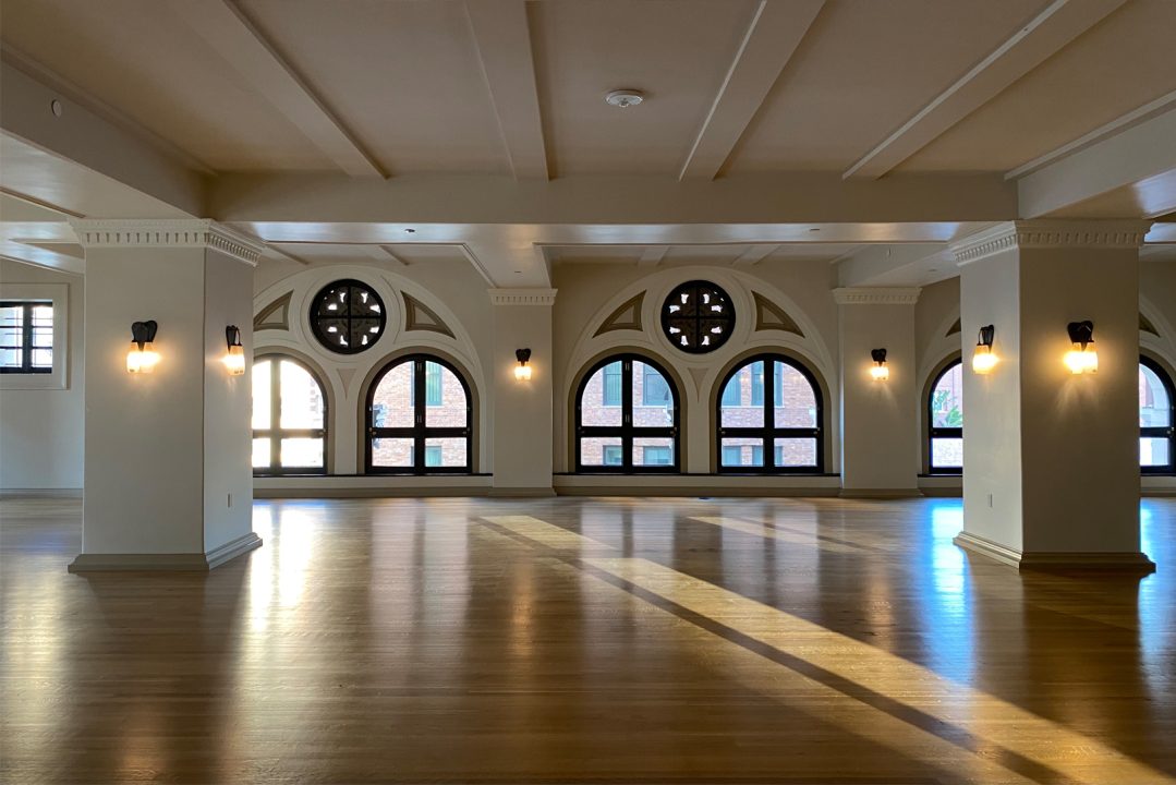 Spacious event venue with arched windows, hardwood floors, and natural light in Downtown Los Angeles