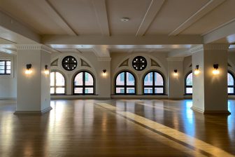 Spacious event venue with arched windows, hardwood floors, and natural light in Downtown Los Angeles