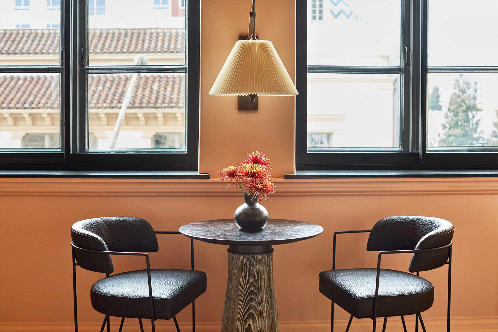 Modern seating nook with window views and floral centerpiece