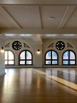 Spacious event venue with arched windows, hardwood floors, and natural light in Downtown Los Angeles