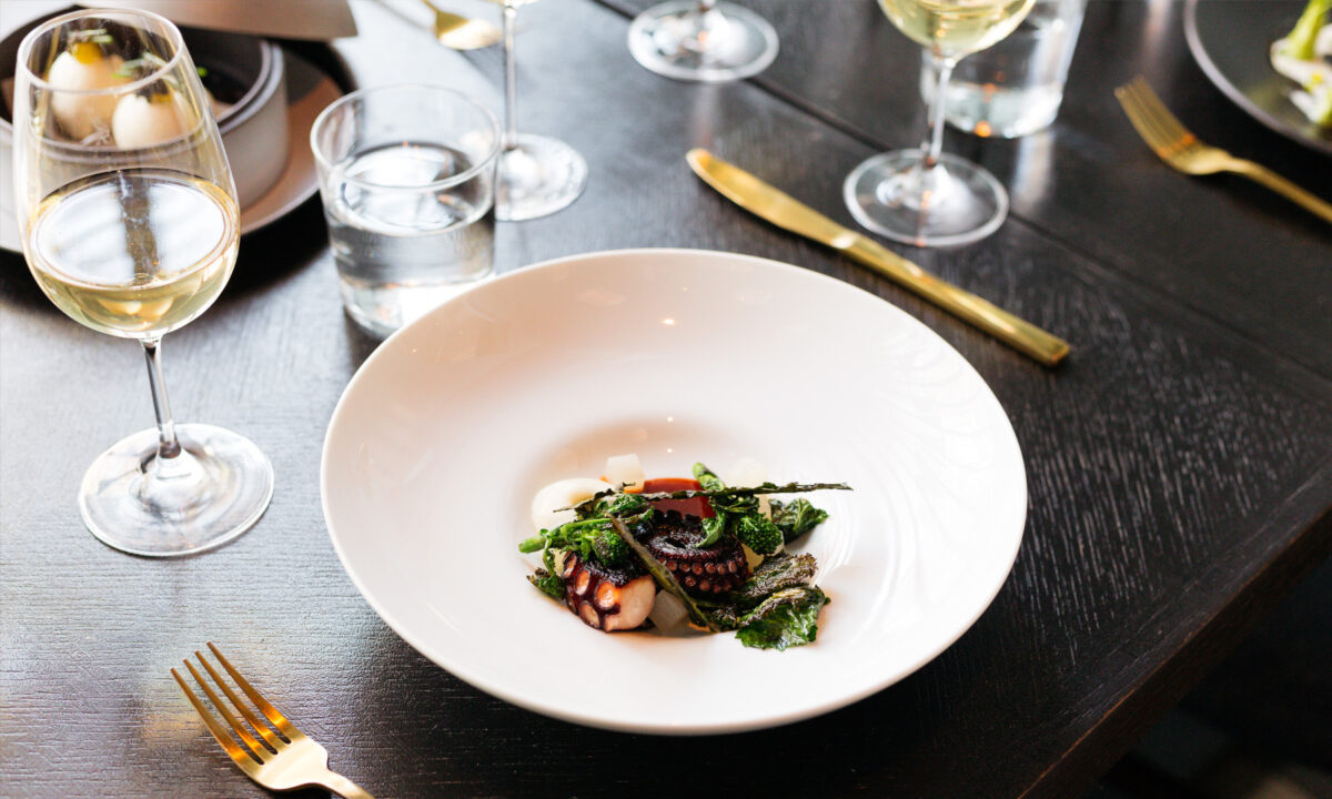 Elegant seafood entrée paired with fine wine in a sophisticated dining setting