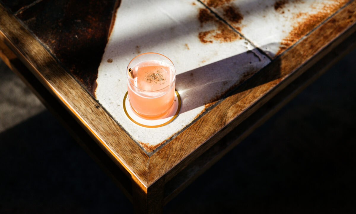 Craft cocktail served on a rustic table with warm ambient lighting at Villon San Francisco Proper