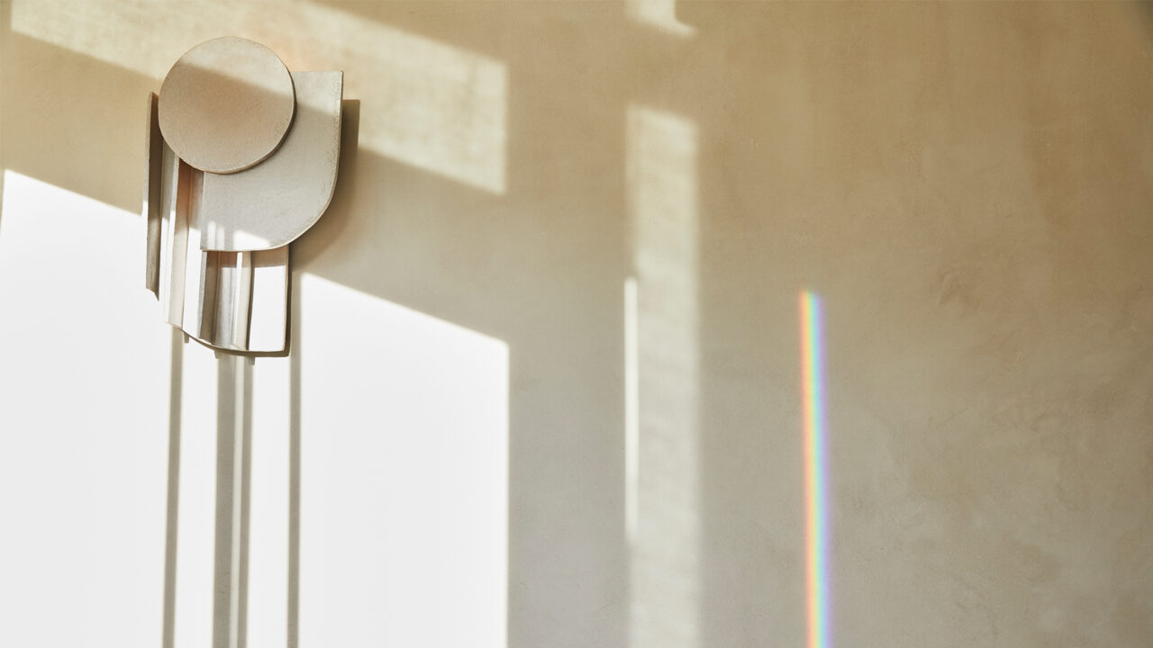 Minimalist wall light with natural sunlight and prism reflection in modern luxury interior