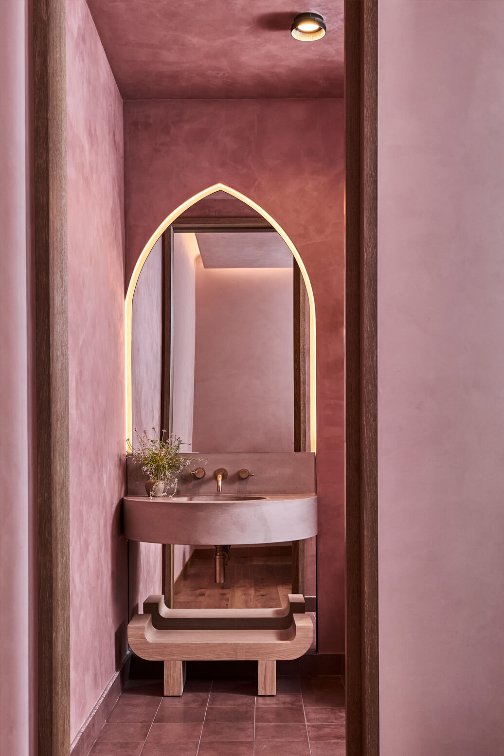 Mirror with a sink and pink walls