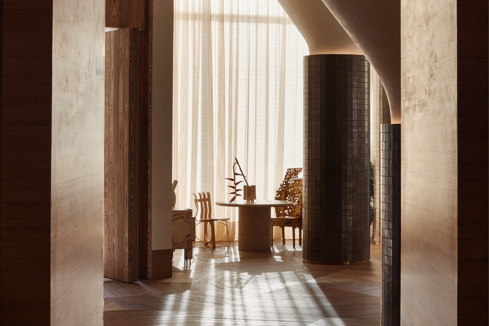 Sunlit hotel lounge with sculptural interiors and warm wood finishes