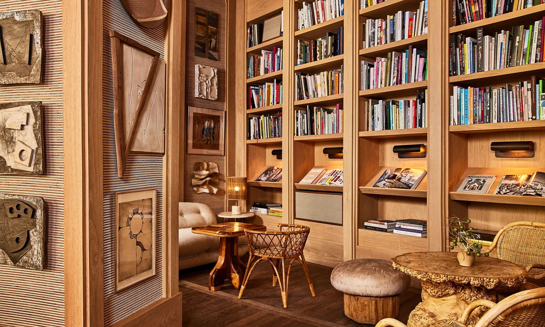 Cozy hotel library lounge with curated bookshelves, artisan decor, warm wood interiors, and intimate seating areas