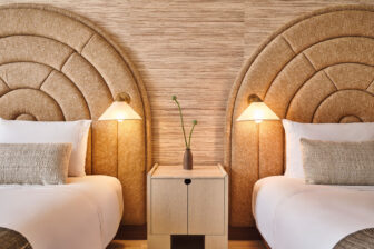 Cozy bedroom with twin beds, wicker headboards, and warm lighting.
