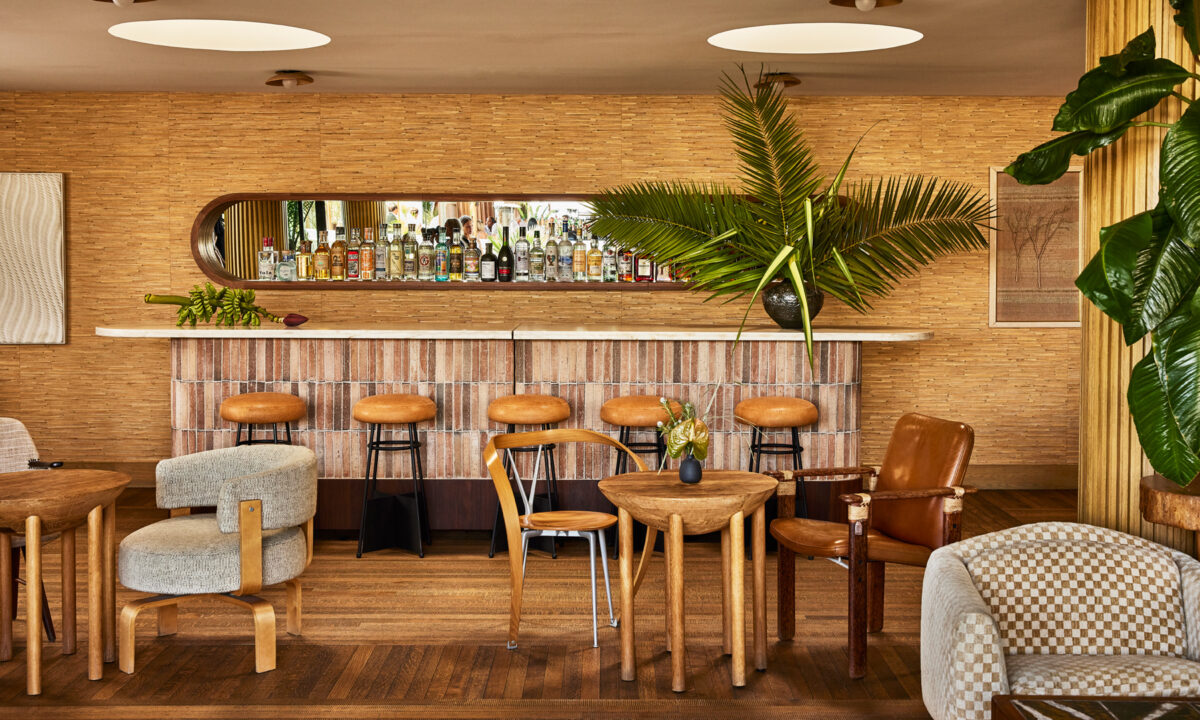 Stylish modern bar with earthy tones, cozy seating, and a tropical plant accent.