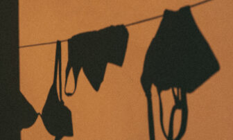 A shadow on the wall indicates clothes hanging on a rope for drying.