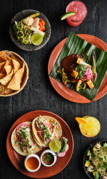 Colorful Mexican spread with tacos, chips, dips, and margaritas