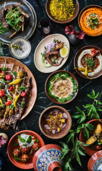Various delicious dishes are presented on plates arranged neatly on the table.