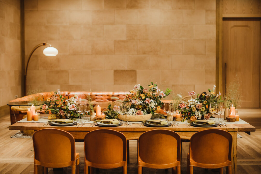Elegant dining setup with floral centerpieces and warm lighting in a cozy setting.