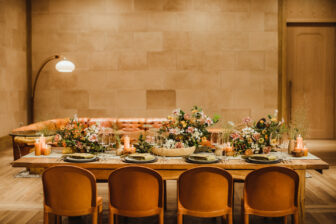 Elegant dining setup with floral centerpieces and warm lighting in a cozy setting.
