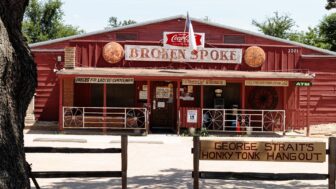 A photo captures Broken Spoke, a dance hall, with a sign reading GEORGE STRAITS HONKY TONK HANG OUT