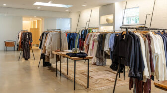 A clothing store showcases its garments on hanging racks for customers to browse.