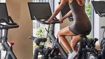 Guest riding a Peloton bike in a modern hotel fitness studio