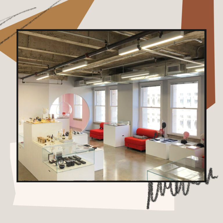 Modern retail showroom with display cases, large windows, and minimalist interior design