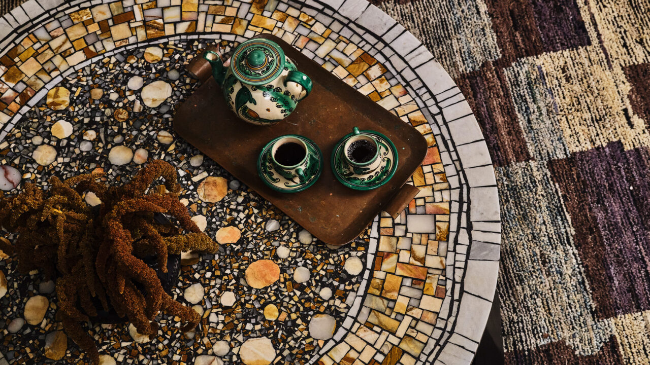 Decorative mosaic table with ceramic tea set and artisanal interior details