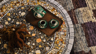 Decorative mosaic table with ceramic tea set and artisanal interior details