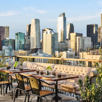 Rooftop terrace dining with panoramic city skyline views.