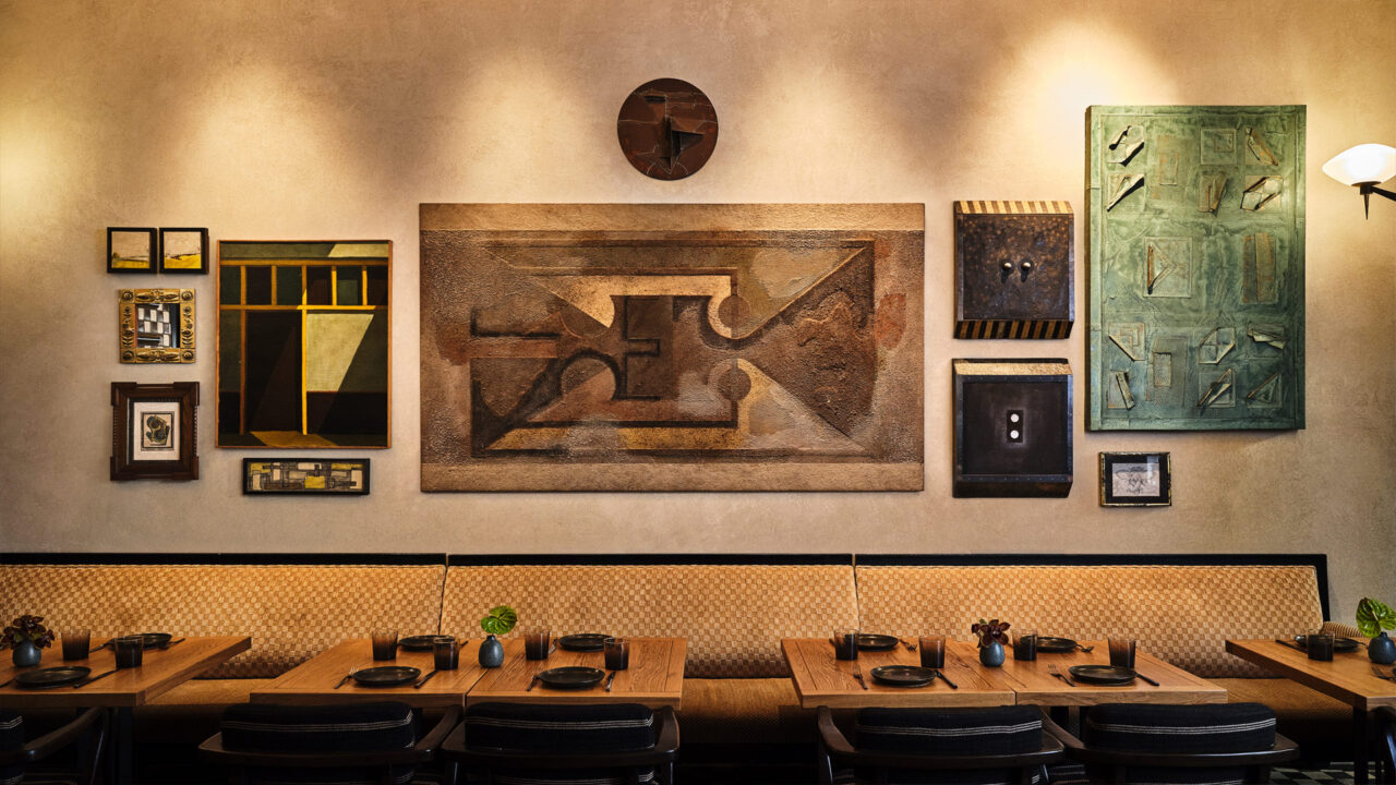 Art filled restaurant dining space with warm lighting and contemporary décor