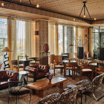 Elegant lounge with leather seating, patterned decor, large windows, and a warm, inviting ambiance