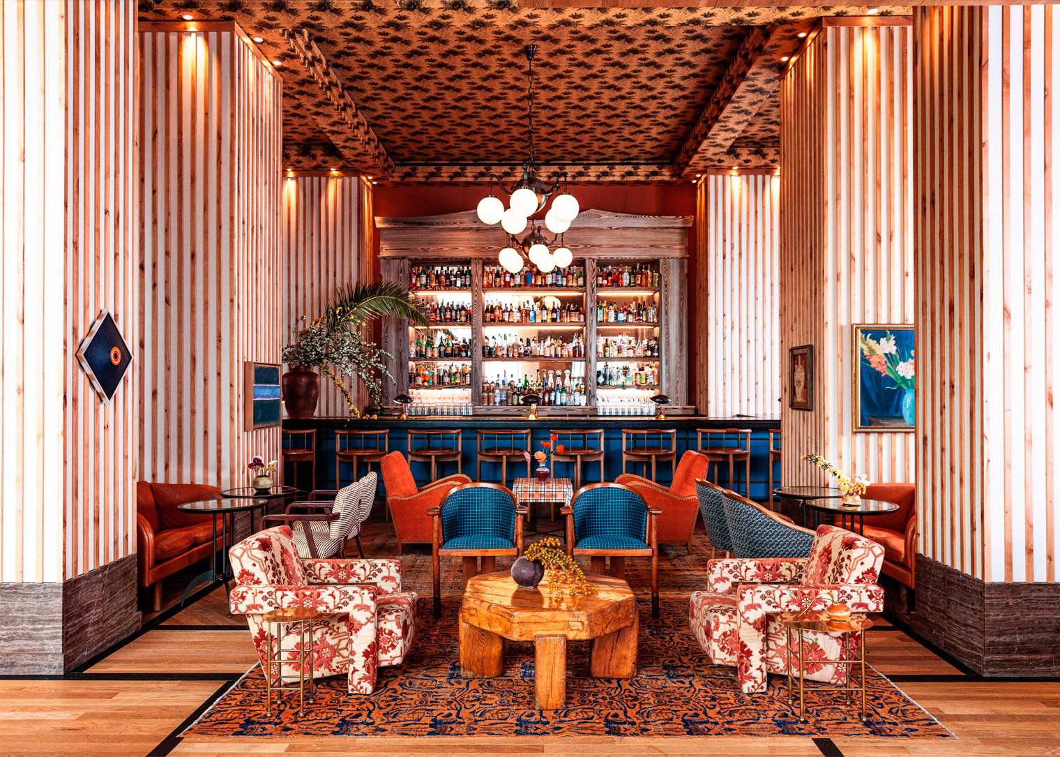 Vibrant lounge with bold patterns and a stylish bar backdrop.
