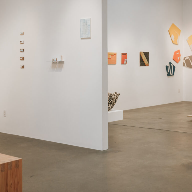 Minimalist art gallery with white walls, abstract works on display, and open concrete floor space
