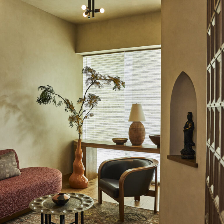 A cozy sofa with a coffee table and small plant pot beside it.