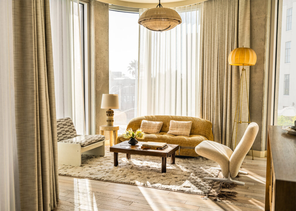 Sunlit luxury suite lounge with floor-to-ceiling windows and modern designer seating