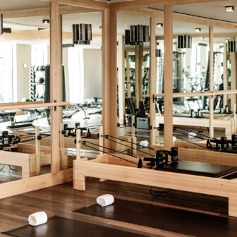 Pilates studio with reformer machines and mirrors