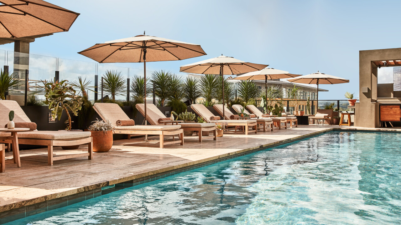 Sun-soaked rooftop pool with loungers and serene, resort-style vibes.