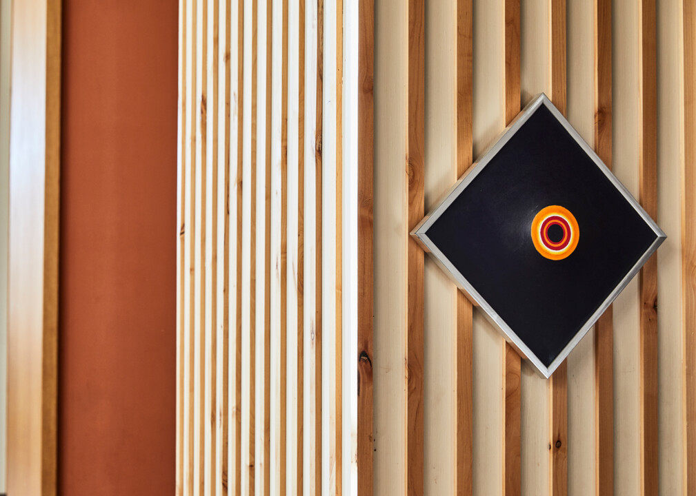 Abstract artwork mounted on a striped wooden wall for Austin property