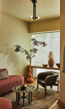 Cozy spa lounge with curved sofa, accent chair, and warm natural decor