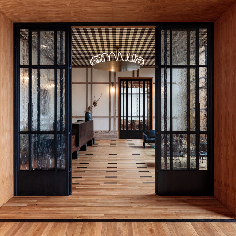 Elegant entryway with glass doors and patterned ceiling
