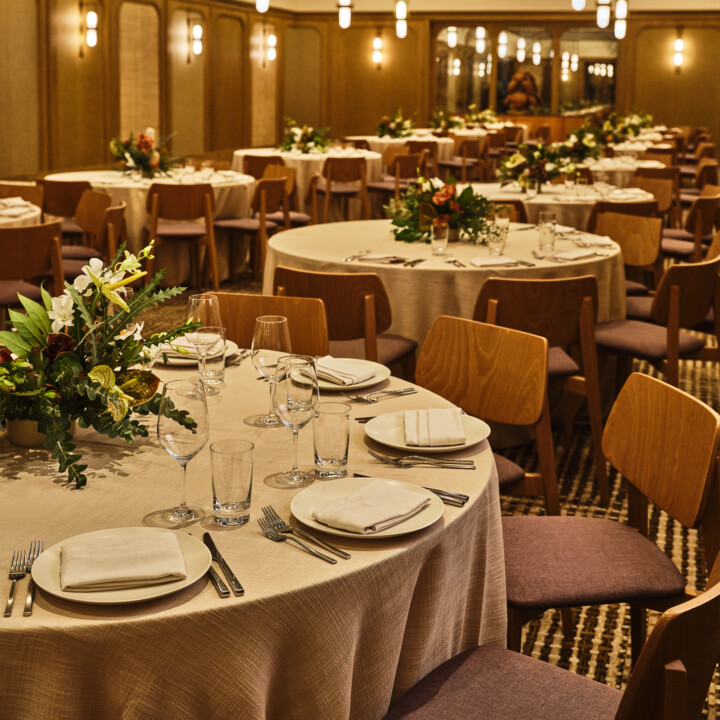 Elegant ballroom dining setup with floral centerpieces for luxury wedding or private event reception