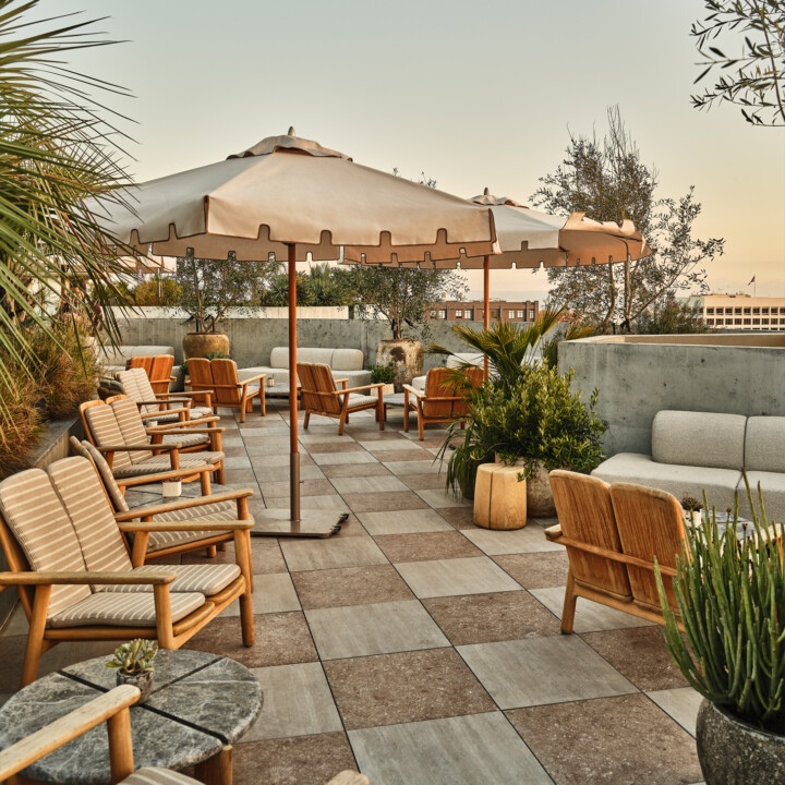 Rooftop terrace lounge with outdoor seating, umbrellas, and panoramic city views