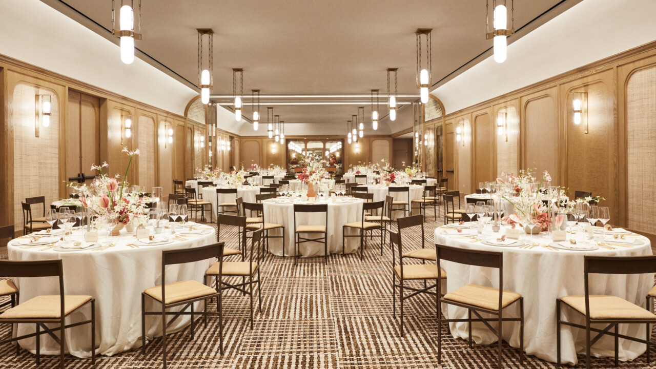 Elegant ballroom setup with floral centerpieces and round banquet tables for luxury event or wedding reception