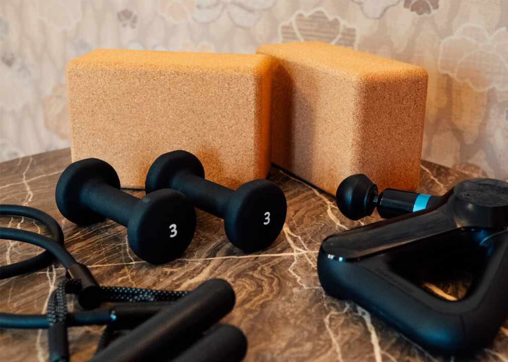 In room wellness equipment with dumbbells, yoga blocks, and fitness accessories on marble tabletop