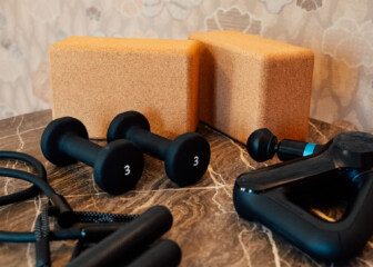 In room wellness equipment with dumbbells, yoga blocks, and fitness accessories on marble tabletop