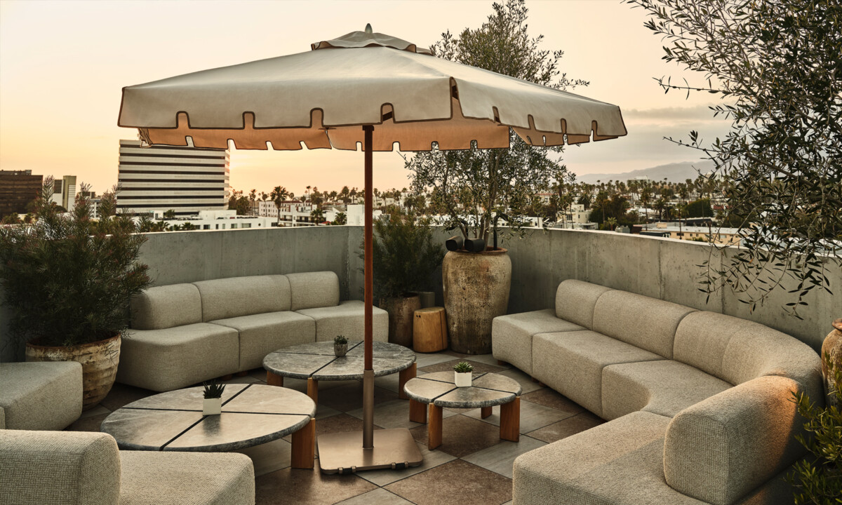 Private rooftop lounge seating with sunset city views and outdoor umbrella seating
