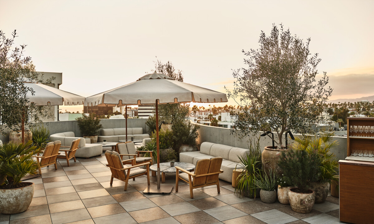 Rooftop terrace lounge with outdoor seating, umbrellas, and panoramic city views