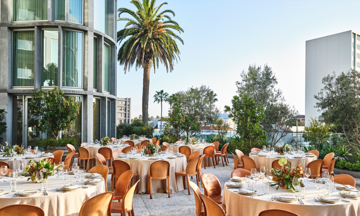 Elegant outdoor dining setup with palm trees and garden terrace seating for private events or celebrations