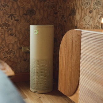 Air purifier in thoughtfully designed wellness hotel room with warm ambient lighting and textured interiors